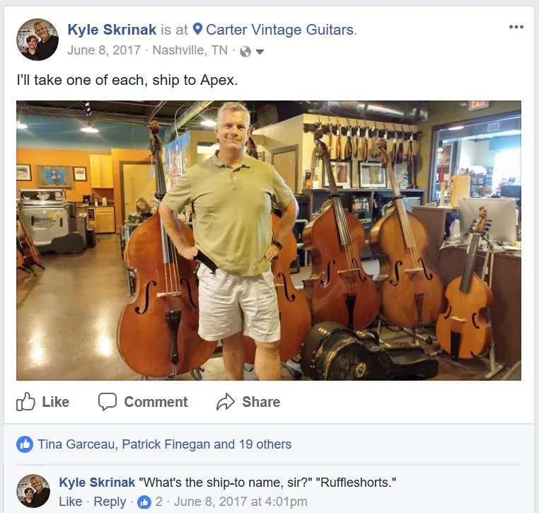 Kyle at Carter Vintage Guitars, surrounded by double basses and string instruments