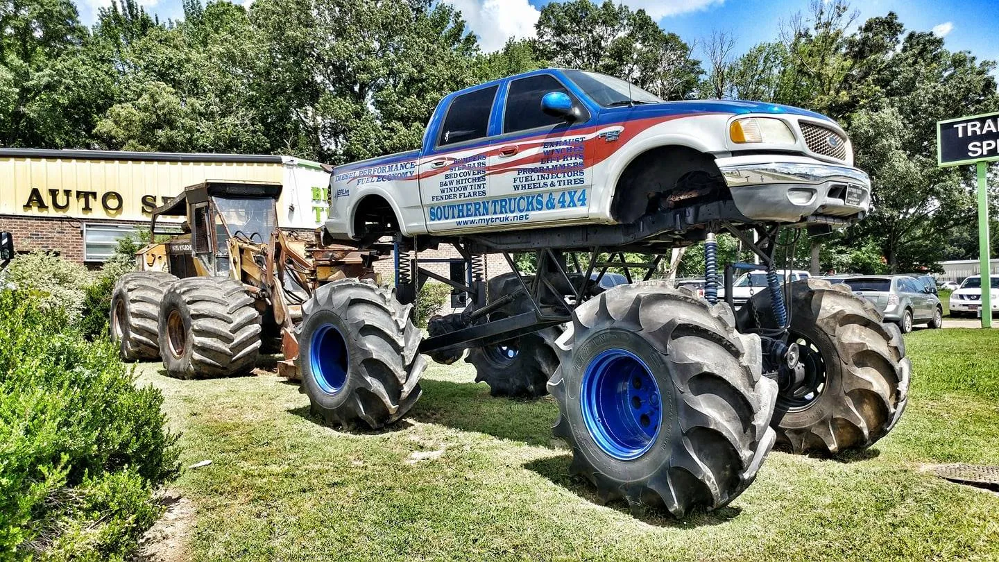 An absurdly tall lifted monster truck parked at an auto shop in Jackson, TN